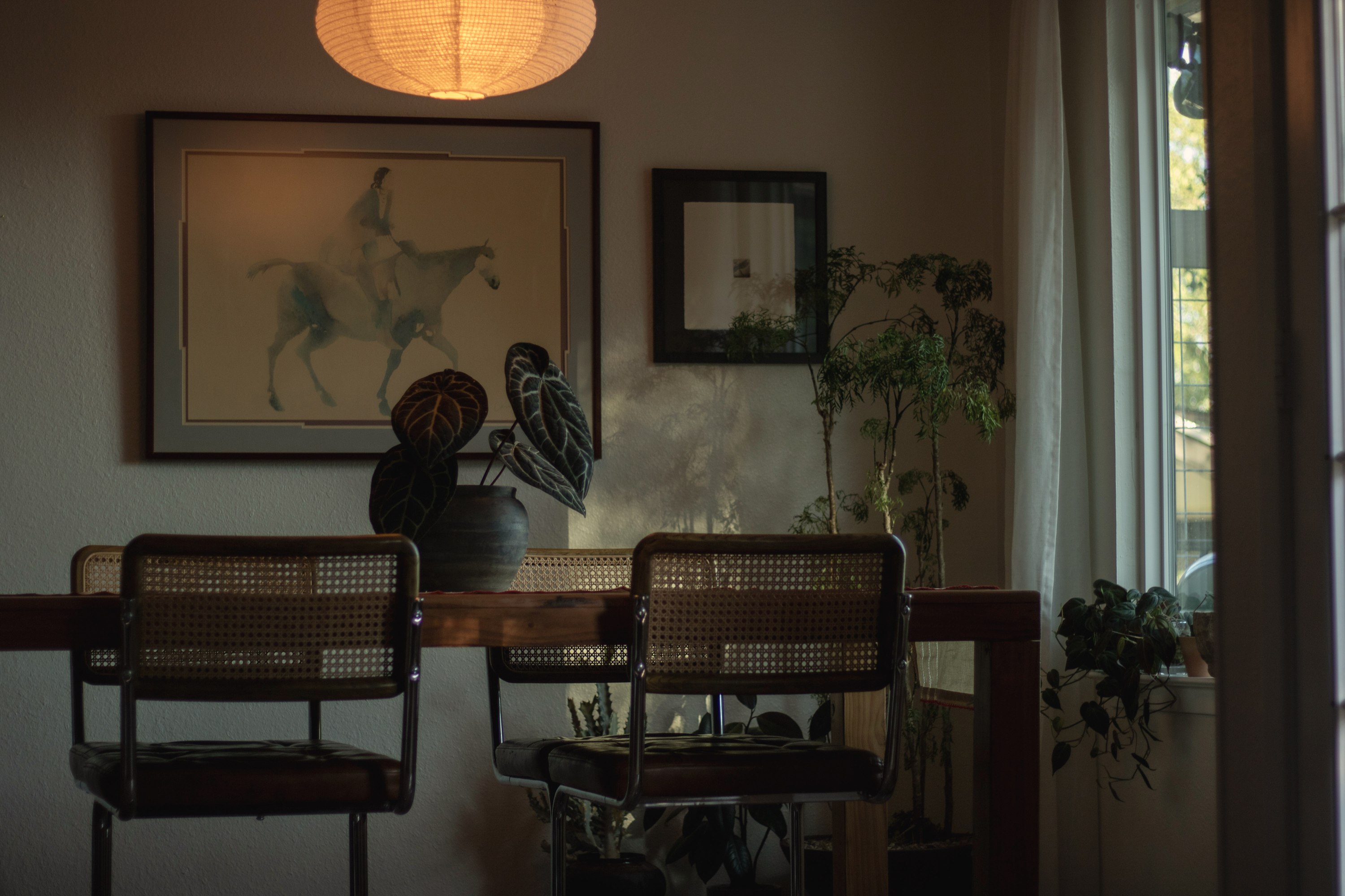 A dining room at dusk under a glowing paper lantern
